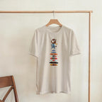 Graduation Bear Discography Tee, Sand Gildan 5000 T-shirt, front graphic print displayed on a wooden hanger
