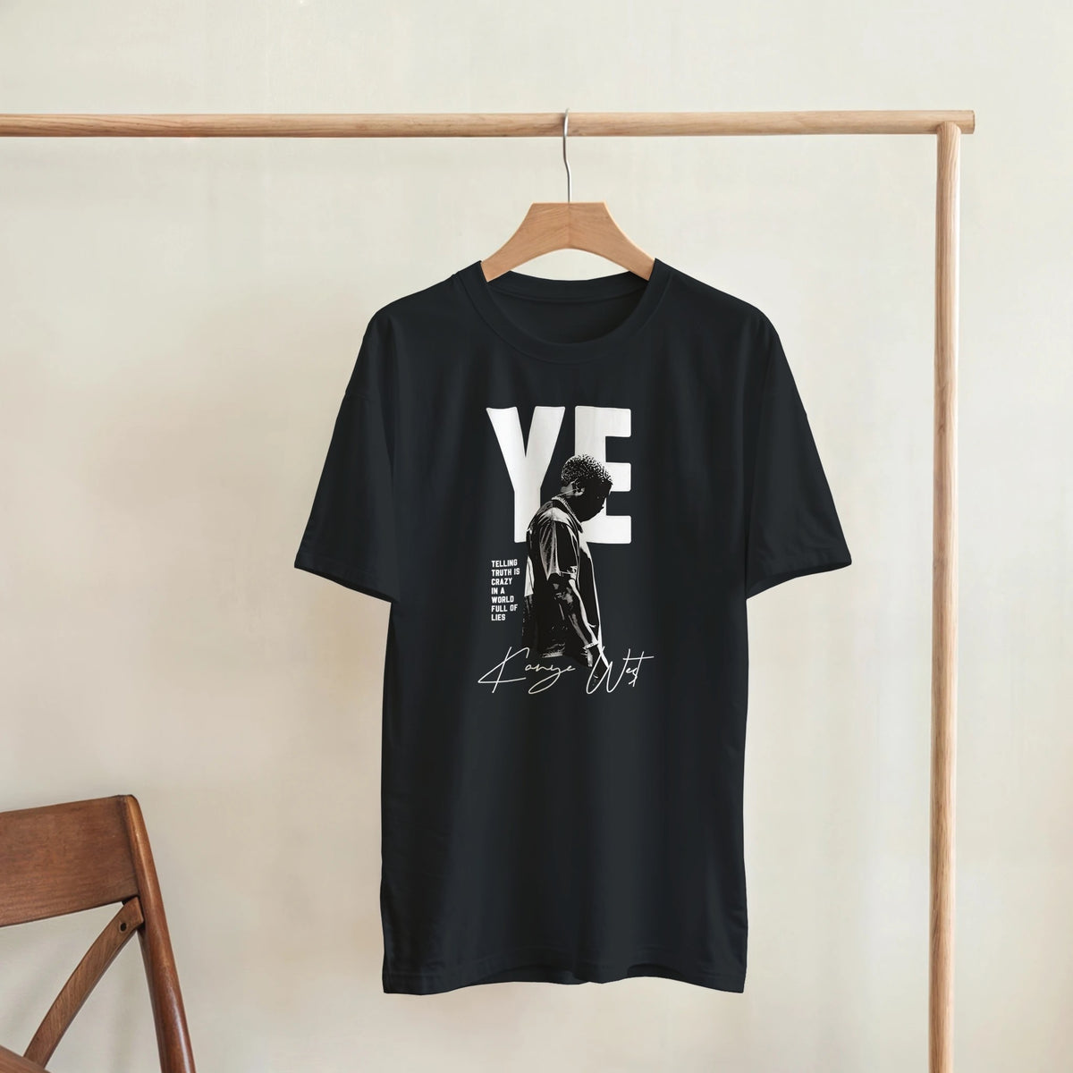 YE Portrait Kanye West Tee, Black Gildan 5000 T-shirt, front graphic print displayed on a wooden hanger