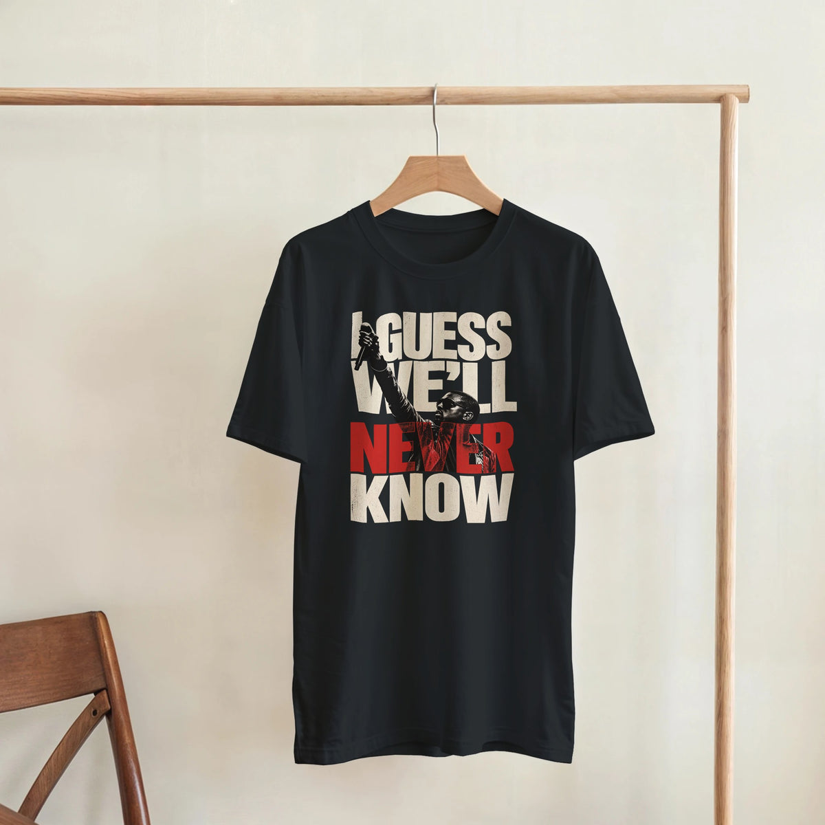 Never Know Kanye West Tee, Black Gildan 5000 T-shirt, front graphic print displayed on a wooden hanger